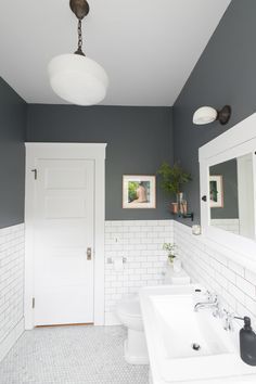 a white bathroom with two sinks and mirrors