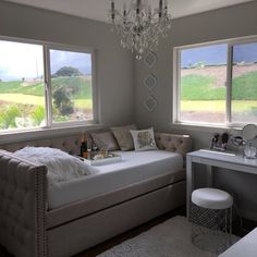 a living room filled with furniture and a chandelier hanging from the ceiling above it