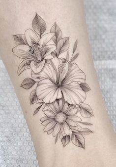 a black and white flower tattoo on the ankle