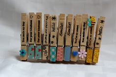 several wooden clothes pins are lined up in a row with words on them and flowers