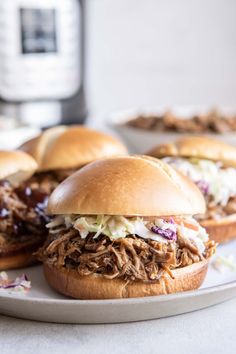 pulled pork sandwiches with cole slaw on a plate