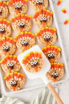 rice krispy treats decorated like turkeys on a tray with candy sticks in the shape of eyes