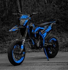 a blue and black dirt bike parked on the street