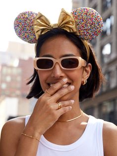 a woman wearing sunglasses and a gold minnie ears headband