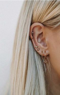 a woman with blonde hair wearing a pair of ear piercings