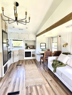 a living room filled with furniture next to a kitchen and dining area in a home