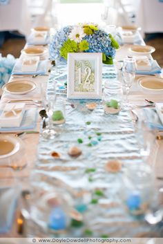 the table is set with blue and green flowers