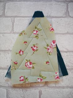 a christmas tree made out of fabric hanging on a brick wall