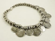 Recently strung necklace with five old one-ruppee coins alternate with six half rupee coins from George V. Coins are dated from 1917 to 1930. The coins are sterling silver and the round beads are also high-grade silver. In very good condition, with a wonderful patina due to use. Dimensions: Length of the necklace: 45 cm (17,72 inches) Big rupee coins: 4 x 3 cm (1,57 x 1,18 inches) Half rupee coins: 3,5 x 2,5 cm (1,38 x 0,98 inches Diameter of the silver beads: 1,2 cm (0,47 inches) Weight: 146 gr Silver Necklace With Coin Pendant For Festivals, Silver Necklaces With Coin Pendant For Festivals, Traditional Silver Coin Necklaces, Traditional Silver Coin Necklace, Silver Coin Pendant Necklace For Festivals, Vintage Oxidized Coin Necklace, Bohemian Silver Coin Necklace, Coin Pendant Necklace For Festivals, Old Ones