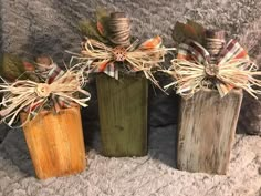 three wooden vases decorated with burlocks and twine bows on a gray carpet