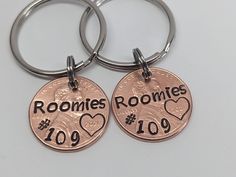 two personalized keychains with one penny and the other has a dog's paw on it