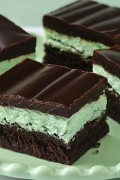 four pieces of cake on a plate with white and green frosting, one piece cut in half