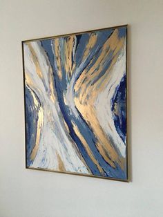 an abstract painting hangs on the wall above a bed in a room with white walls