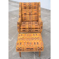 an orange chair and footstool sitting next to each other on the cement floor