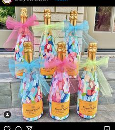 four bottles filled with colorful confetti sitting on top of a stone floor next to each other