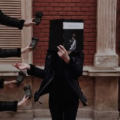 a group of people standing around each other with their hands in front of a book