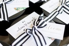 black and white wedding favors tied with ribbon on top of each others'place cards