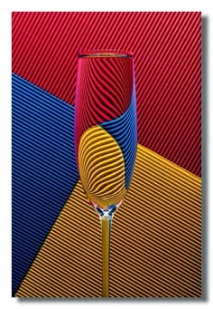 a wine glass sitting on top of a table next to a red and blue striped wall