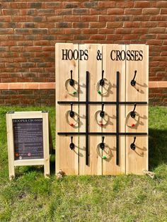 a wooden board game set up in the grass next to a sign that says hoop's and crosses