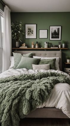 a bedroom with green walls and white bedding, plants on the shelves above it