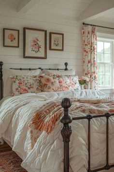 a bed with white comforter and pillows in a bedroom next to two framed pictures on the wall