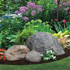 a garden with flowers and rocks in the middle