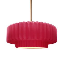 a pink pendant light hanging from a gold colored ceiling fixture with a white back ground