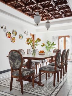 a dining room table with chairs and plates on the wall