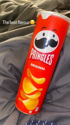 a can of pringles sitting on top of a bed