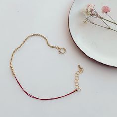 Close-up of hand wearing delicate bracelet of gold chain and red thread with gold beads detail at center. Threaded Bracelets, Ward Off Evil Spirits, Good Luck Bracelet, The Color Red, Symbol Of Protection, Chic Bracelet, Red Thread, Luck Charm, Luck Charms