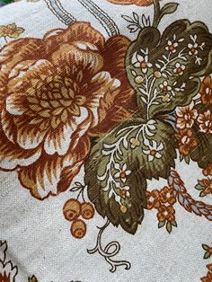 close up view of the back of a floral print fabric with orange and green flowers on it