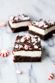 three pieces of chocolate peppermint cheesecake with candy canes on the side