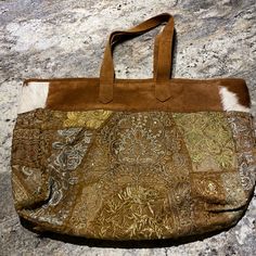 Beautiful Cowhide Tote With Embroidered Designs. Never Used. Size 16 X 22. Bohemian Gold Bags For Everyday Use, Bohemian Gold Tote Shoulder Bag, Gold Bohemian Tote Shoulder Bag, Bohemian Gold Shoulder Bag, Bohemian Gold Bag For Daily Use, Gold Bohemian Bag For Daily Use, Gold Bohemian Tote Bag, Embroidered Designs, Embroidered Design