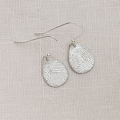 Keep your loved one with you always, with these lovely teardrop fingerprint earrings. Handcrafted in solid sterling silver, these earrings feature a beautiful teardrop design that is stylish, yet simple. Your earrings can be made with the same fingerprint on both teardrops or they can be made with a different fingerprint on each earring. The teardrops hang from sterling silver ear wires. The intricate details of your fingerprint are captured with exceptional precision using my perfected techniqu Silver Teardrop Stamped Jewelry, Engraved Teardrop Earrings For Gift, Engraved Teardrop Sterling Silver Earrings, Personalized Silver Teardrop Jewelry, Hypoallergenic Sterling Silver Teardrop Pendant Earrings, Hypoallergenic Sterling Silver Teardrop Drop Earrings, Hypoallergenic Sterling Silver Teardrop Pendant, Sterling Silver White Gold Teardrop Earrings Gift, White Gold Teardrop Earrings In Sterling Silver As Gift