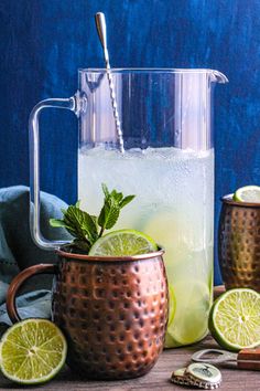 a pitcher filled with ice and limes