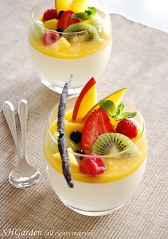 two glasses filled with fruit on top of a table