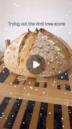 a loaf of bread sitting on top of a wooden table with snow falling around it