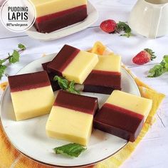 four pieces of cake sitting on top of a white plate next to some strawberries