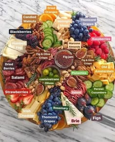 a plate filled with different types of fruits and vegetables on top of a marble table