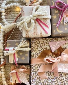 several wrapped presents sitting on top of a table next to beads and other items that are tied together