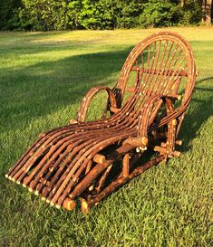 a chair made out of logs sitting in the grass