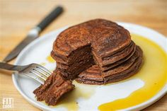 a stack of chocolate pancakes on a plate with a fork