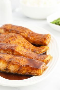 two pieces of chicken covered in sauce on a white plate