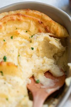 a close up of a casserole dish with mashed potatoes and meat in it