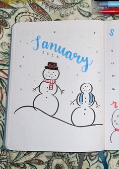 an open notebook with two snowmen and the words january written in blue on it