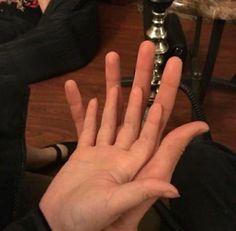 a person holding their hand up in the air with both hands on top of each other