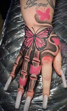 a woman's hand with pink butterflies on it and the word love written in black ink