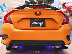 the back end of an orange honda car