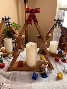 a christmas tree made out of wood with candles and decorations on the table next to it