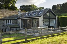 a house with a wooden fence in front of it and grass on the other side